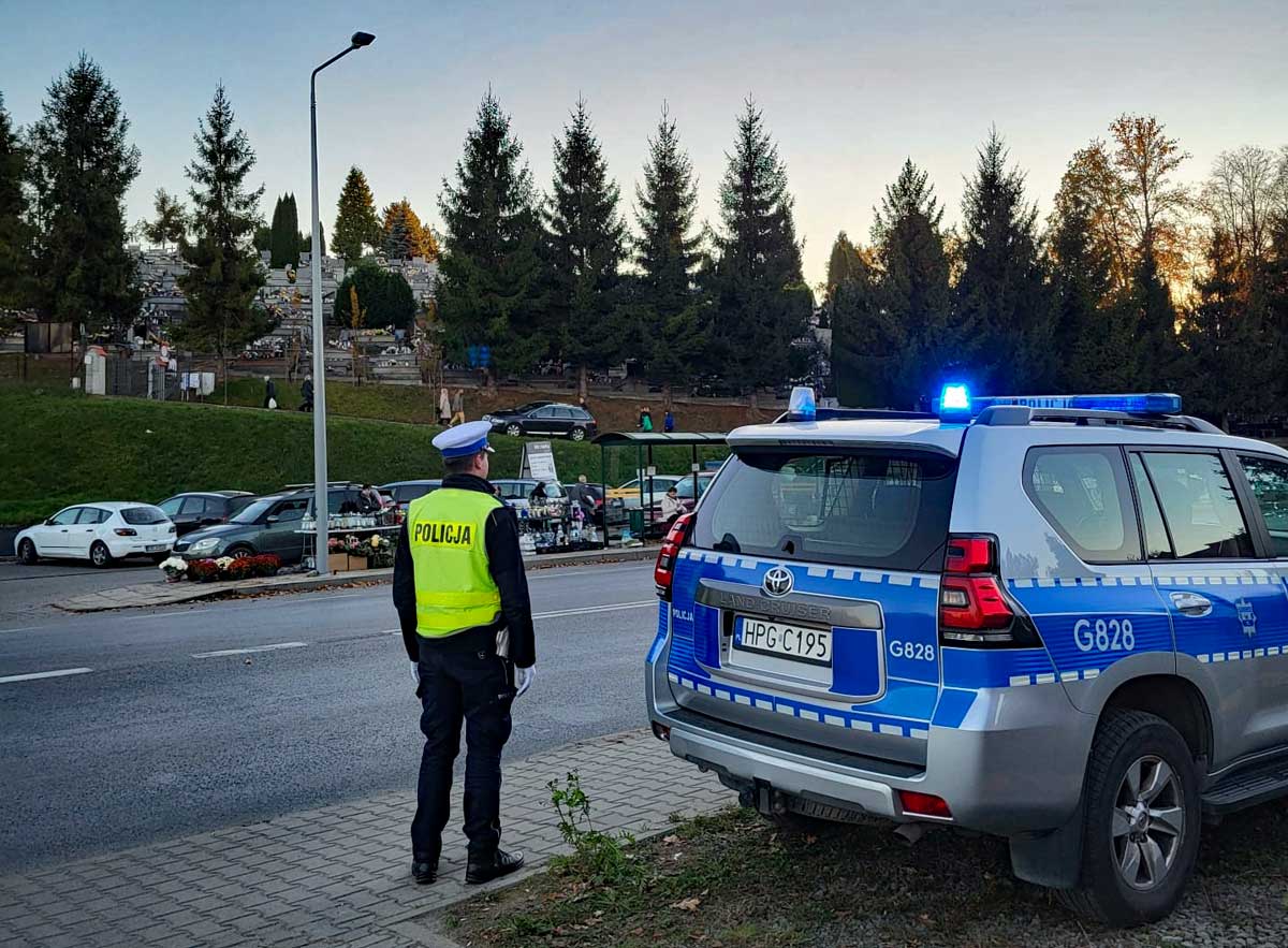 Wszystkich Świętych 2024 statystyki; funkcjonariusz ruchu drogowego dba o bezpieczeństwo w pobliżu cmentarza