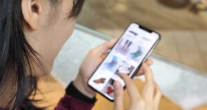 Oszczędzanie na zakupach online - człowiek ze smartfonem w ręku