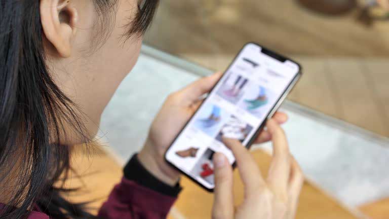 Oszczędzanie na zakupach online joom pl - człowiek ze smartfonem w ręku