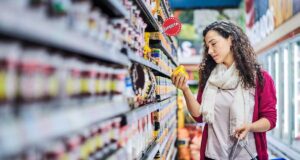 ekspozytory produktów veraco.pl. Kobieta przy regale sklepowym ogląda produkt