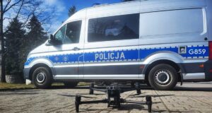 policyjny dron za nim oznakowany radiowóz