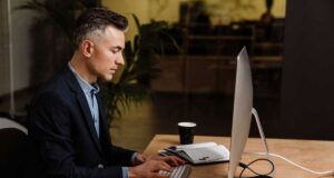 Studia podyplomowe, które pomogą Ci zrobić karierę w finansach studia podyplomowe w Krakowskiej Szkole Biznesu UEK. młody mężczyzna przy klawiaturze, przed ekranem