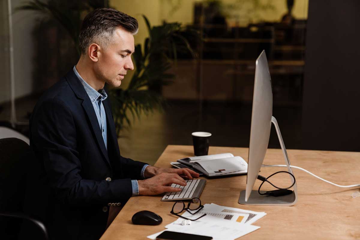 studia podyplomowe w Krakowskiej Szkole Biznesu UEK. młody mężczyzna przy laptopie