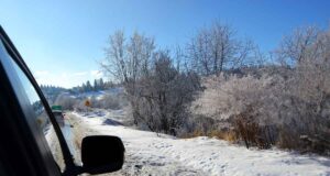 Policja: niskie temperatury na Sądecczyźnie. Widok zaśnieżonej drogi i bok auta