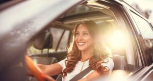 Pierwszy wynajem samochodu: 5 rzeczy, które musisz sprawdzić w protokole przed odebraniem kluczyków Pierwszy wynajem samochodu - dolcar.auto.pl - uśmiechnięta kobieta za kierownicą