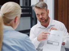 Bramont - bramy, okna, drzwi. mężczyzna w białej koszuli wskazuje na dokument trzymany w ręku